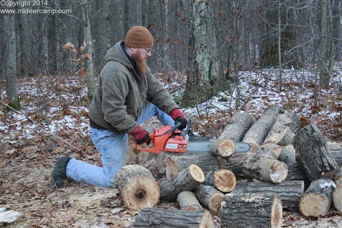 Kruger using a chainsaw to cut firewood